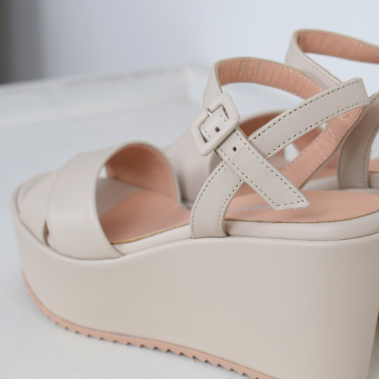 A flat pale pink sandal with large platform and ankle strap 