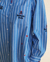 A close-up of a blue and white vertically striped long-sleeve button-up shirt with 'Ballade Folk' embroidered on the chest pocket.