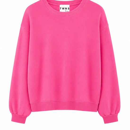 A bright pink crewneck sweatshirt with balloon sleeves and ribbed cuffs, shown flat against a white background. The neck label shows the brand 'TWNS'.