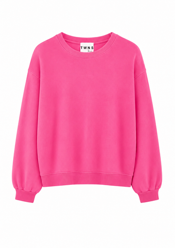 A bright pink crewneck sweatshirt with balloon sleeves and ribbed cuffs, shown flat against a white background. The neck label shows the brand 'TWNS'.
