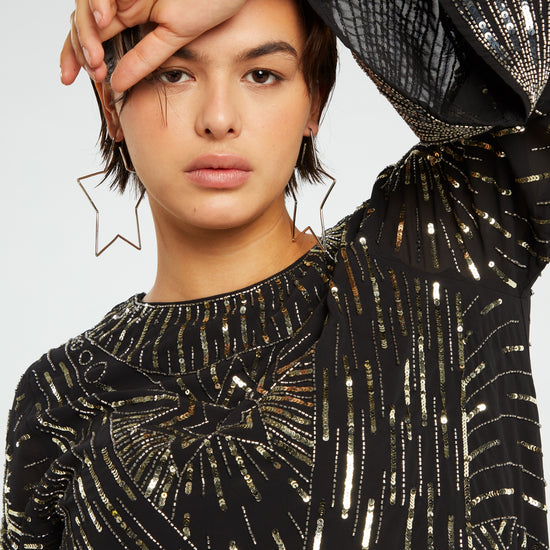 Black mini dress with long wide sleeves and gold sequin details throughout