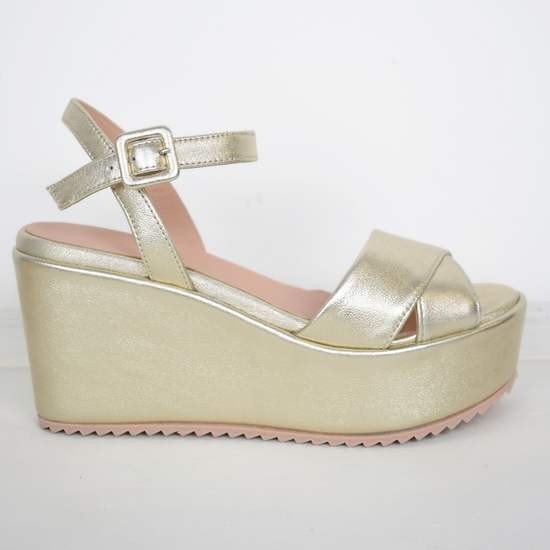 A flat gold sandal with large platform and ankle strap 