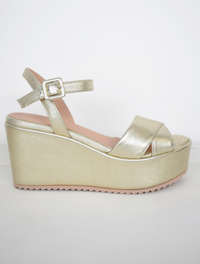 A flat gold sandal with large platform and ankle strap 