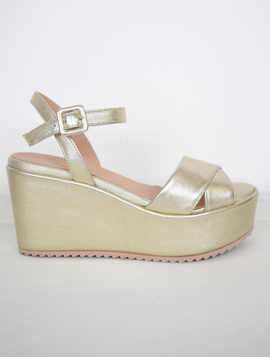 A flat gold sandal with large platform and ankle strap 