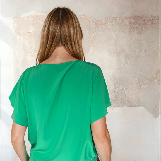 Rear view of green flutter sleeve top from Sirens