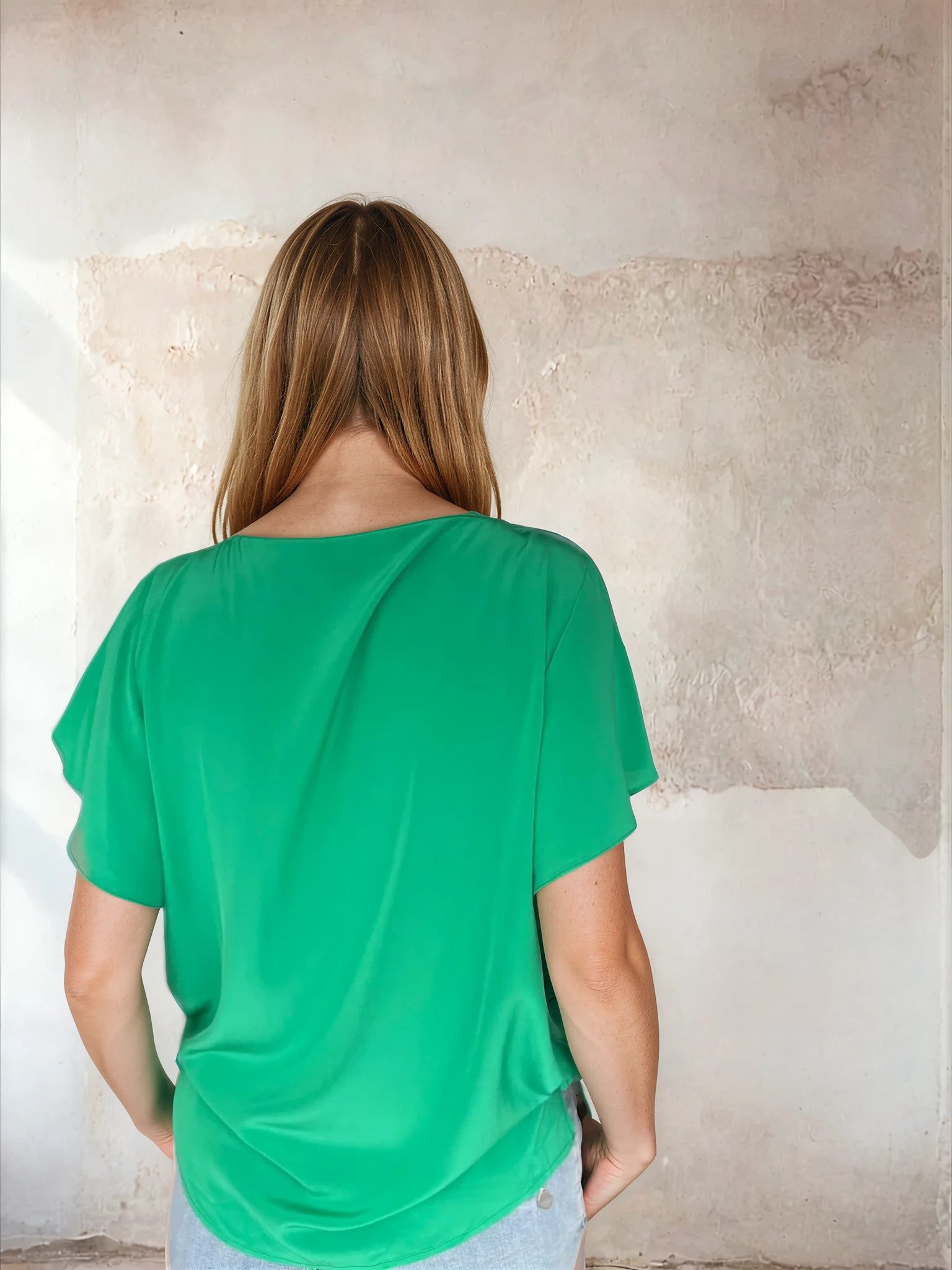 Rear view of green flutter sleeve top from Sirens