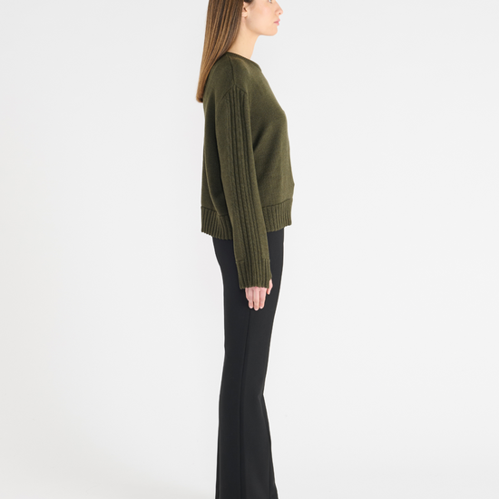 Dark green jumper with round neck, and ribbed hem and cuffs. Side view.