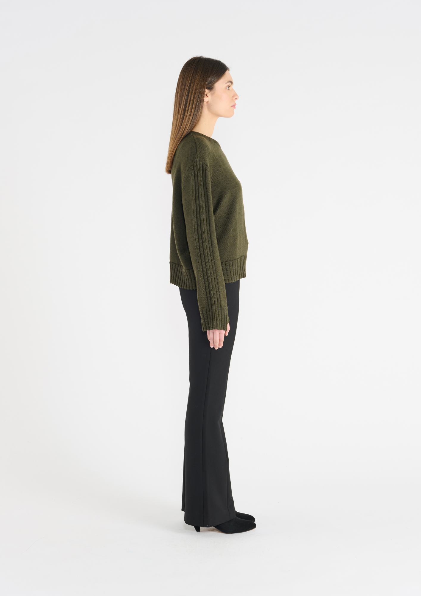 Dark green jumper with round neck, and ribbed hem and cuffs. Side view.