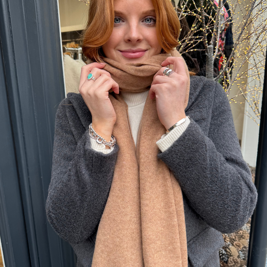 Model wearing grey coat and camel cashmere scarf.