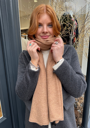 Model wearing grey coat and camel cashmere scarf.