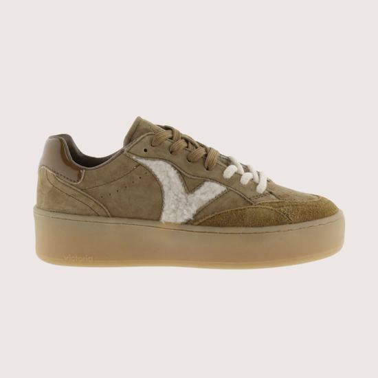 A low-top platform sneaker in olive green suede and white faux fur, featuring a thick tan sole and white laces, shown from a side profile on a light gray background.