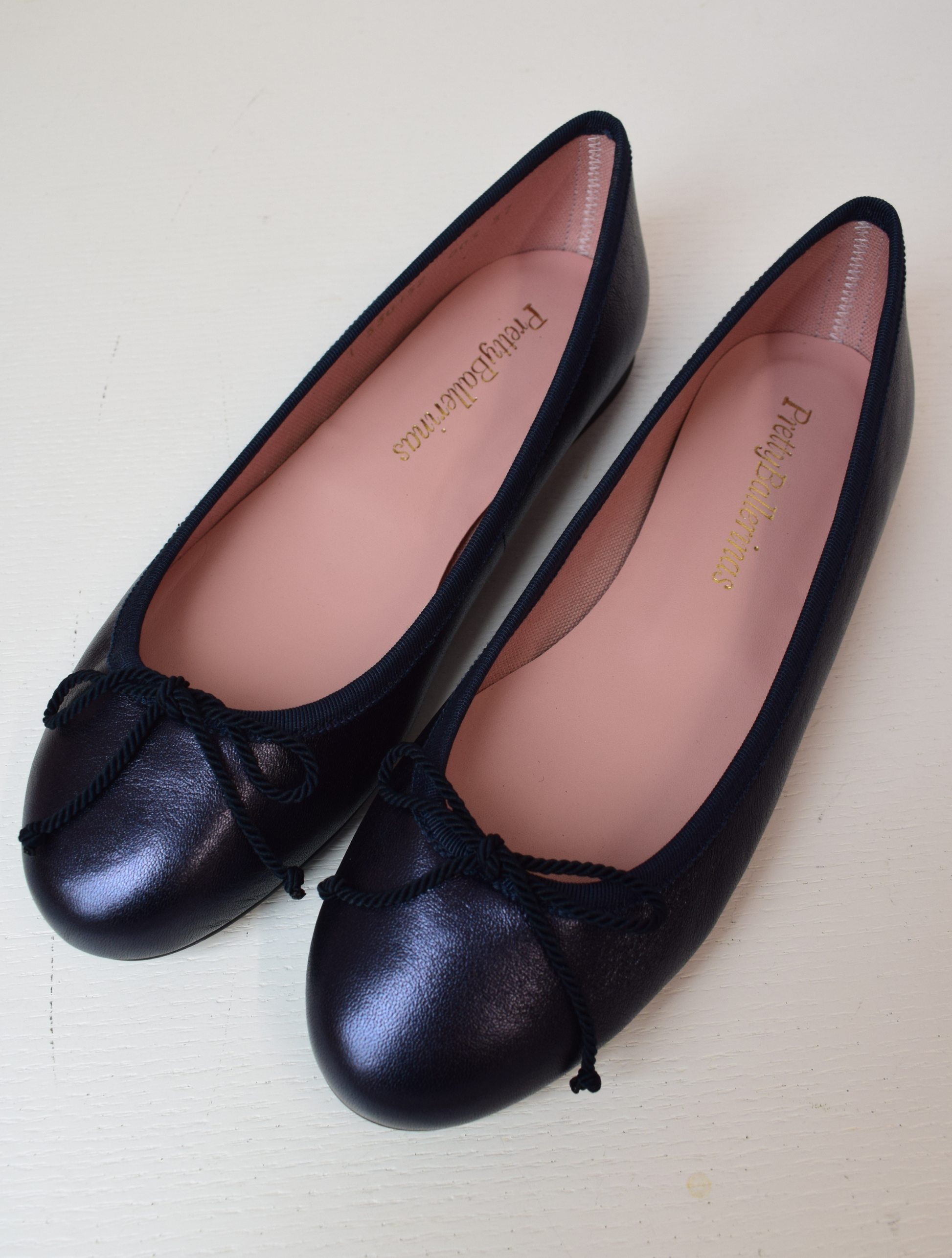 Shimmer navy blue classic round toe ballet pumps with navy thin ribbed binding and navy thin rope bow on toe