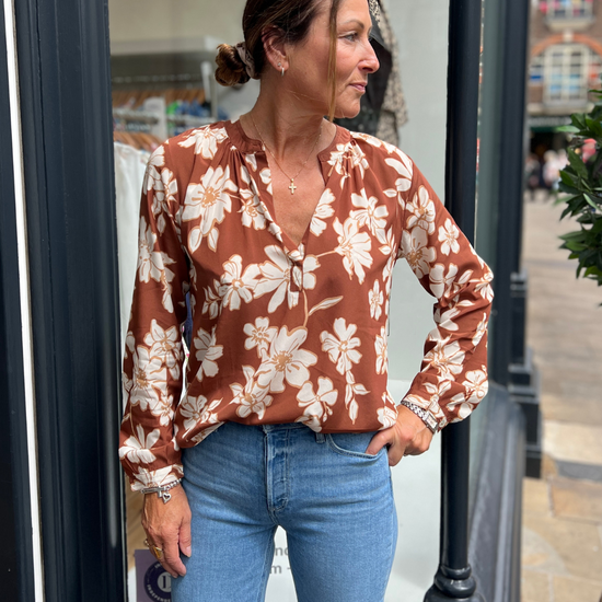 A tan top with white flowers 