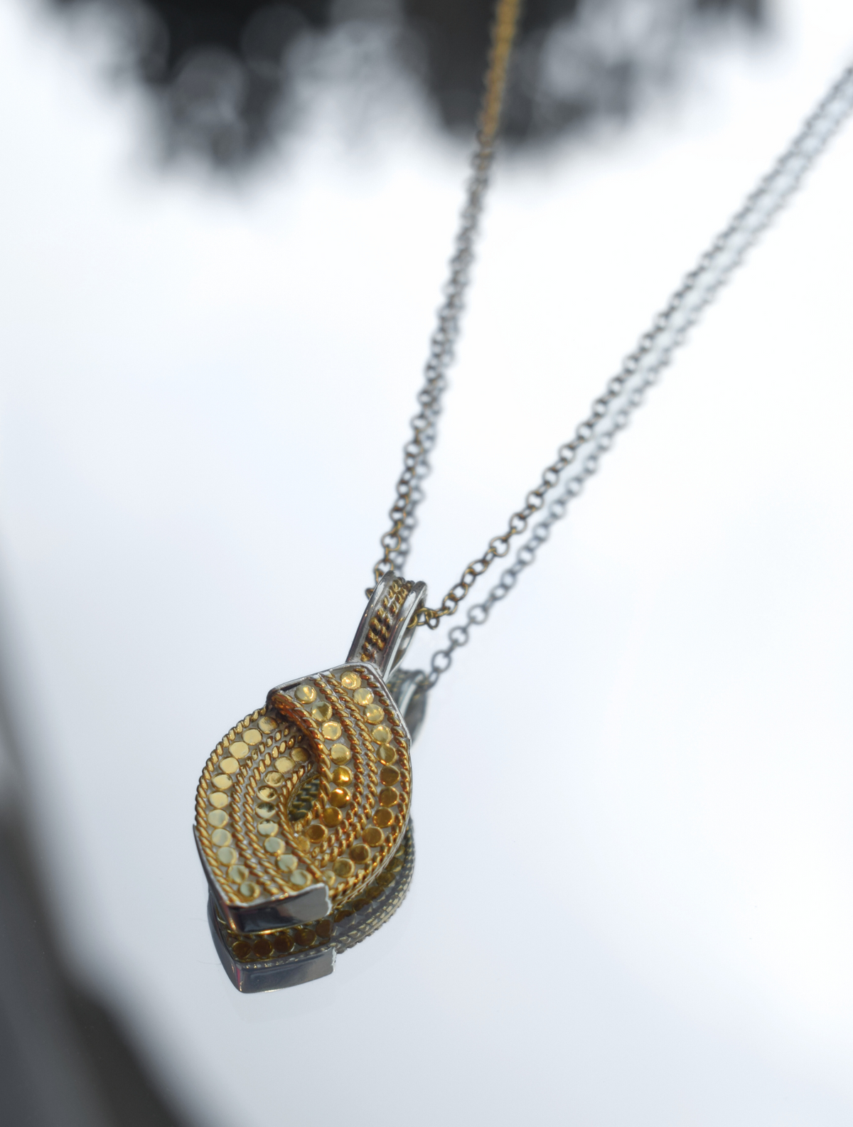 Gold chain with gold woven pendant with small gold plated dots