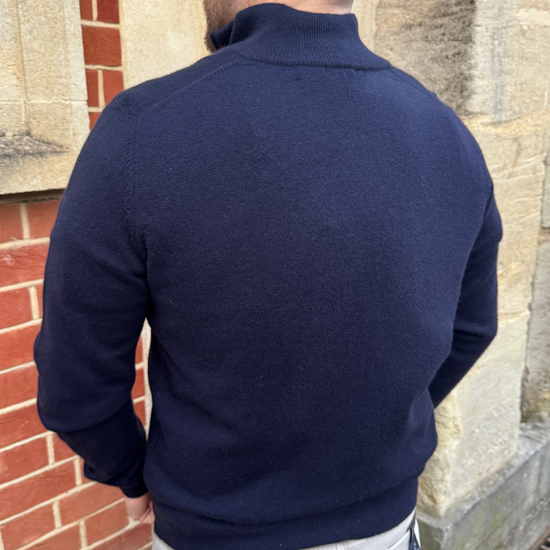 Male model wearing a navy cashmere quarter zip jumper.