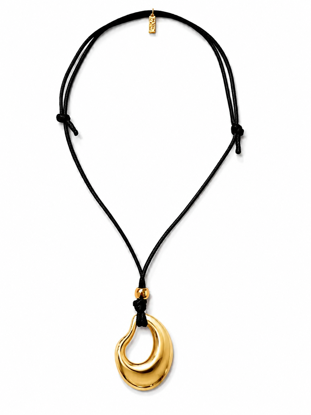 Gold pendant on a black cord against a white background