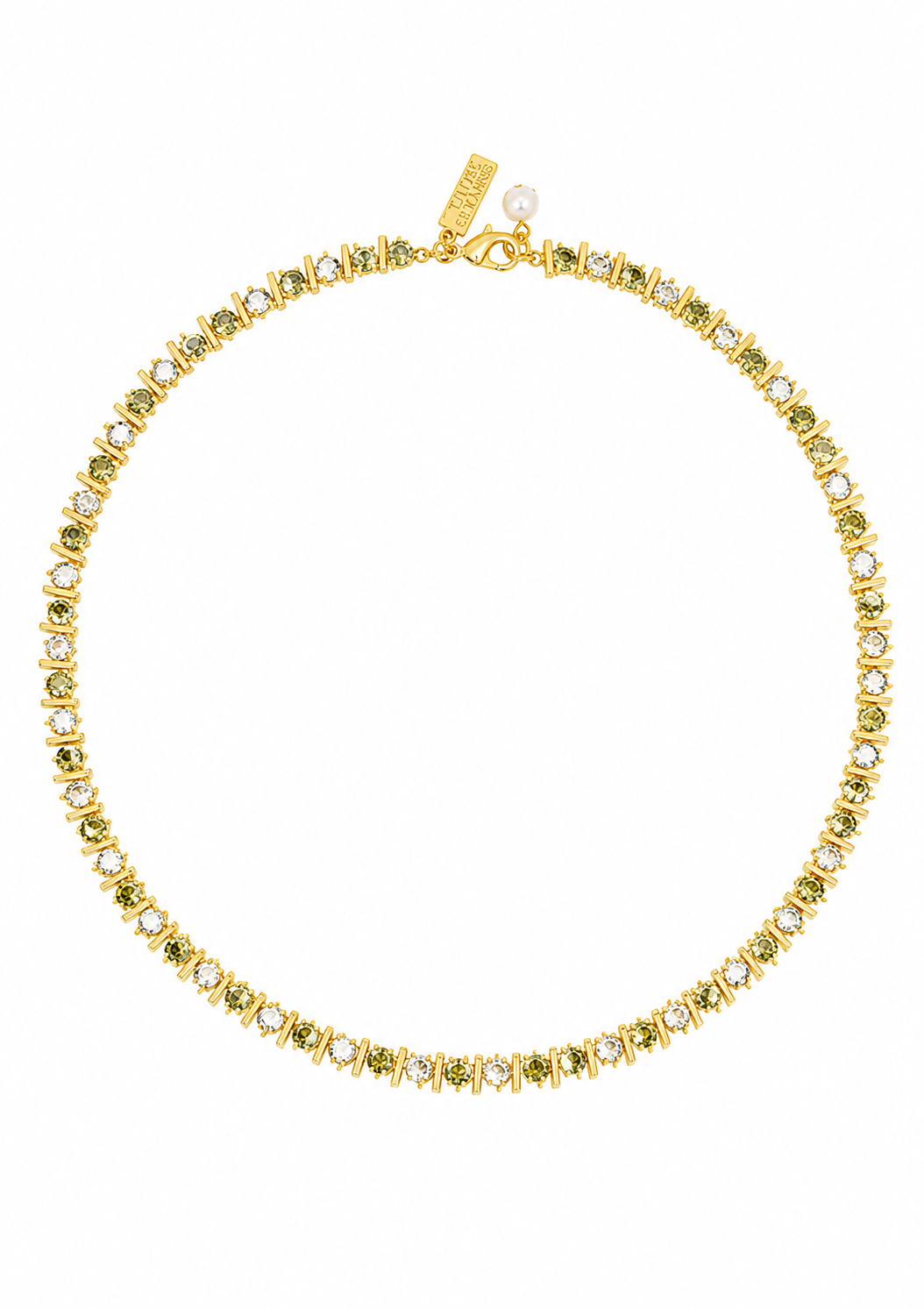 A gold tennis necklace featuring small green gemstones and clear stones, displayed on a clean white background. A gold tag is attached near the clasp.