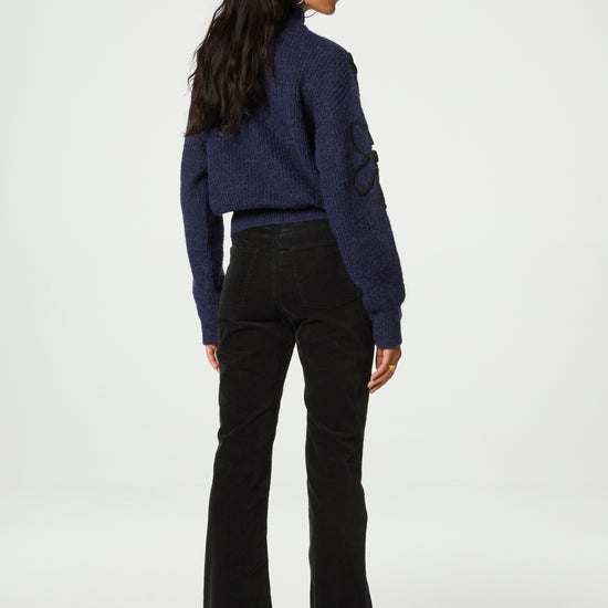 Navy turtleneck jumper with black knitted floral details