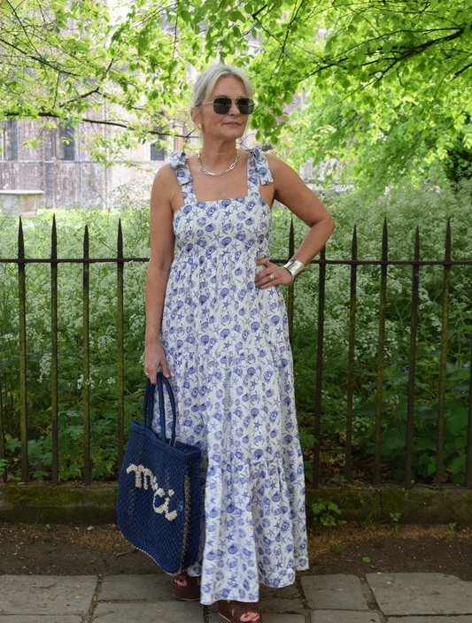 Strappy summer dress with ecru background and blue sea shelll and crab print with tiered skirt