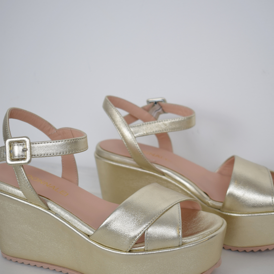 A flat gold sandal with large platform and ankle strap 