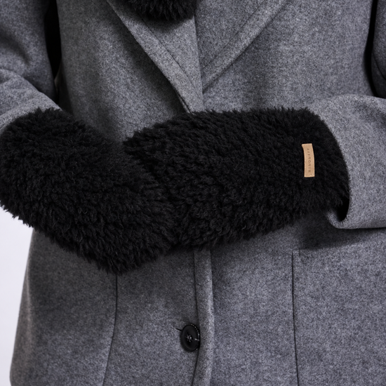 Close-up of a gray wool coat with black faux-fur trim on the collar and cuffs, featuring a small tan brand tab.