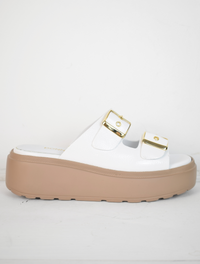 White platform slider with double strap gold metallic buckles and taupe coloured rubber platform sole