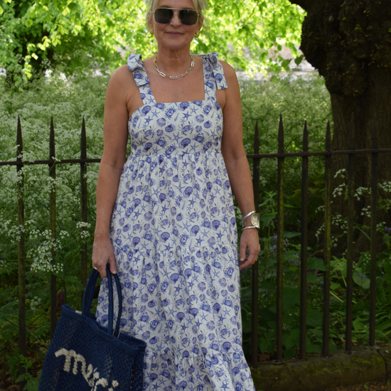 Strappy summer dress with ecru background and blue sea shelll and crab print with tiered skirt