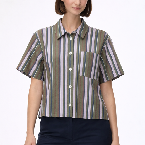 woman wearing striped shirt with blue trousers on a plain background 