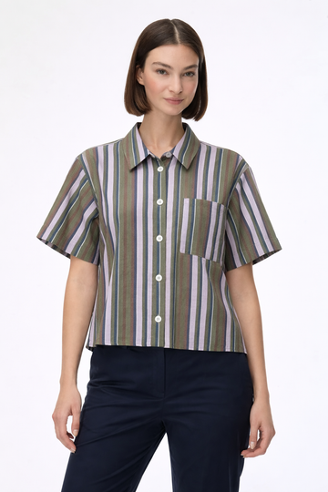 woman wearing striped shirt with blue trousers on a plain background 