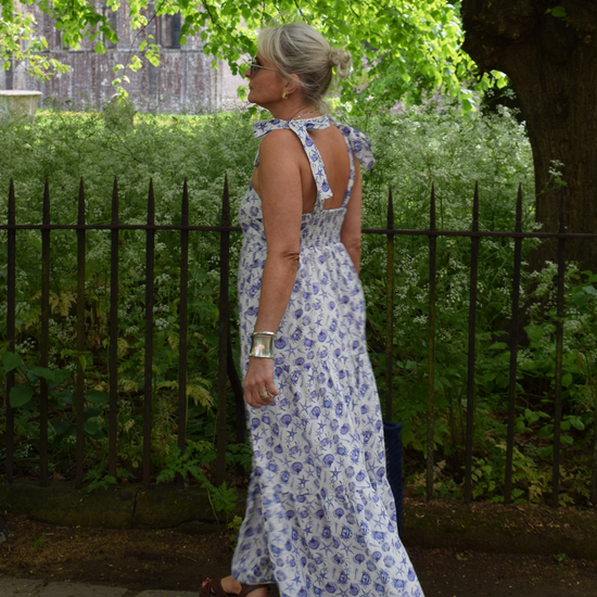 Strappy summer dress with ecru background and blue sea shelll and crab print with tiered skirt