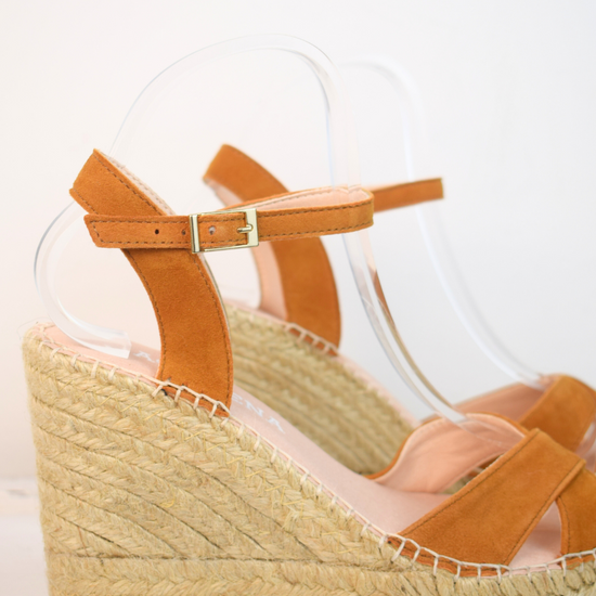 Wedge sandals with a tan cross cover on the toes