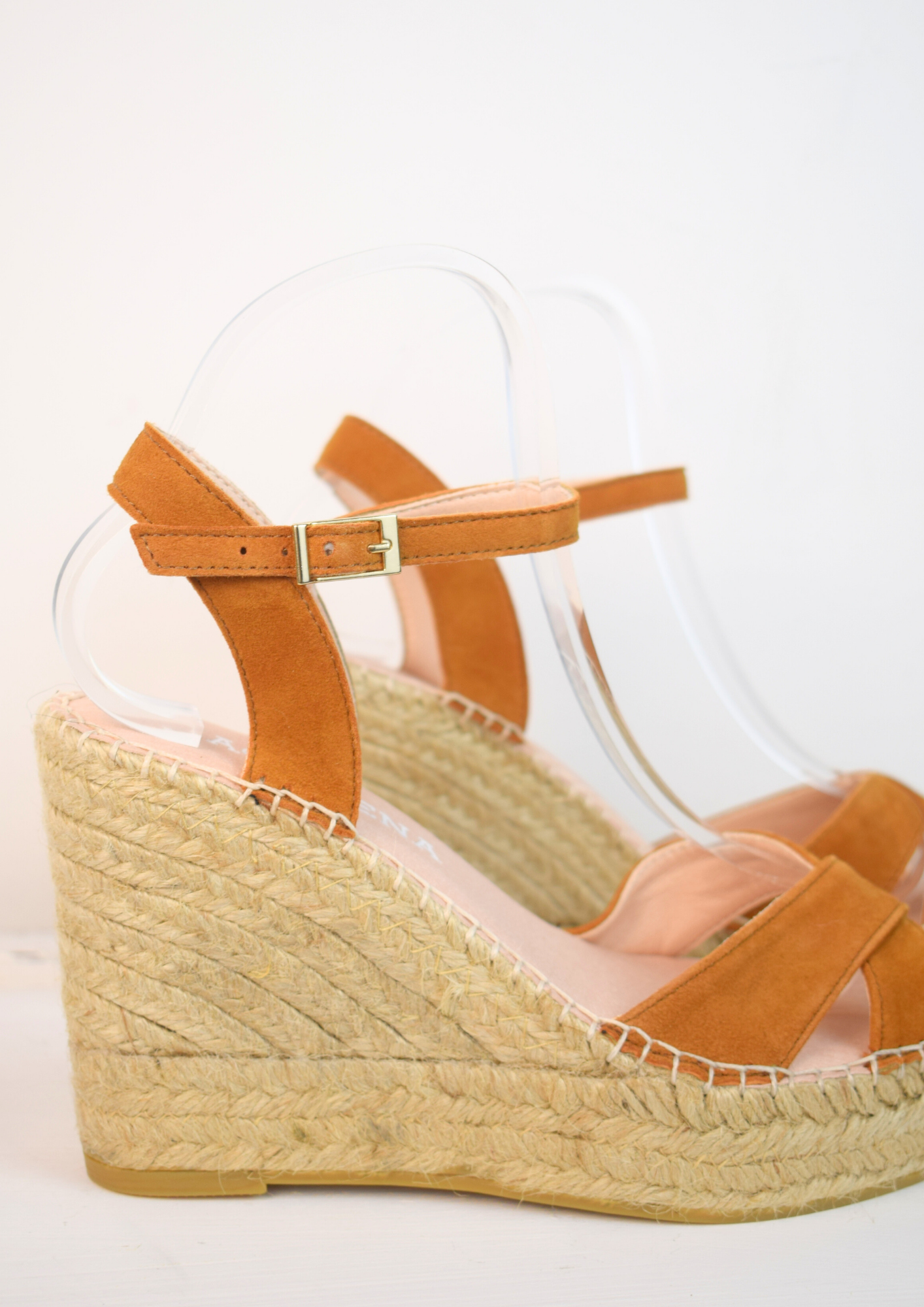 Wedge sandals with a tan cross cover on the toes