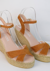 Wedge sandals with a tan cross cover on the toes