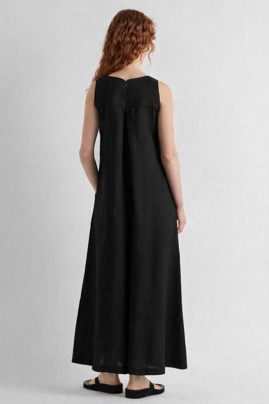 Woman wearing a black sleeveless dress on a white background
