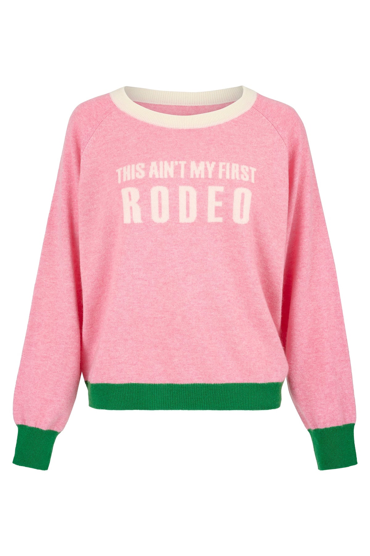 Pink crew neck cashmere raglan sleeved jumper with "this ain't my first rodeo" in cream with cream neckline and green cuffs and hem