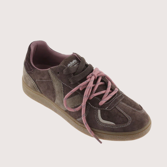 A low-top sneaker in dark brown suede and canvas with dusty pink laces and a tan gum sole, shown from a side profile on a light gray background.