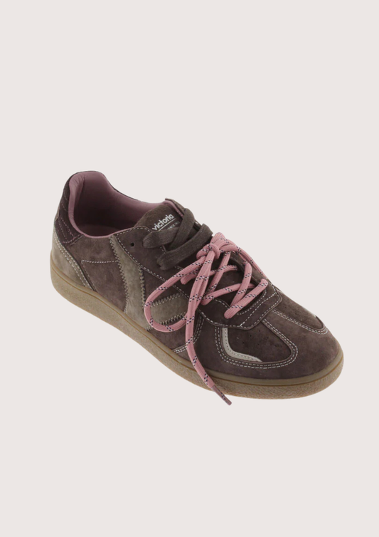 A low-top sneaker in dark brown suede and canvas with dusty pink laces and a tan gum sole, shown from a side profile on a light gray background.