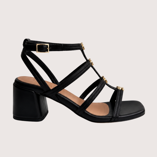 Black sandal with multiple straps on a light gray background