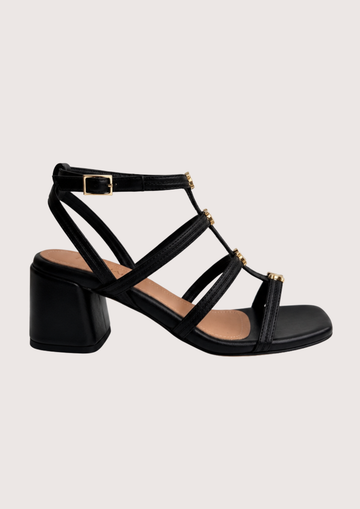 Black sandal with multiple straps on a light gray background
