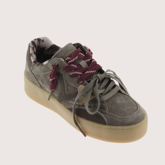 A low-top platform sneaker in dark gray suede and leather, featuring a thick beige gum sole, gray laces, and burgundy ribbon laces tied in a bow.
