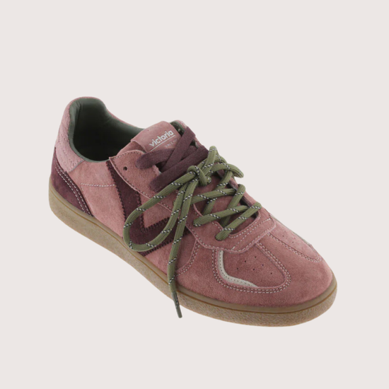A low-top suede sneaker in dusty rose pink with olive green laces and a tan rubber sole, shown on a light beige background.