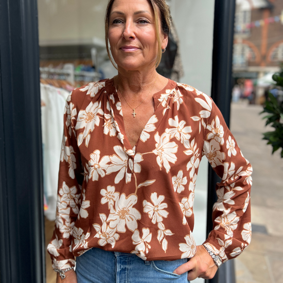 A tan top with white flowers 