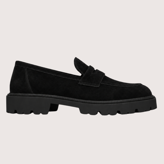 Black suede loafer with a black sole on a grey background