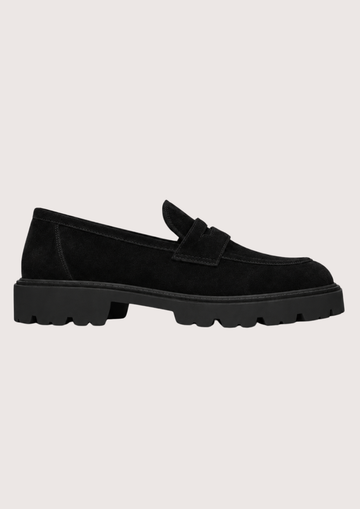 Black suede loafer with a black sole on a grey background