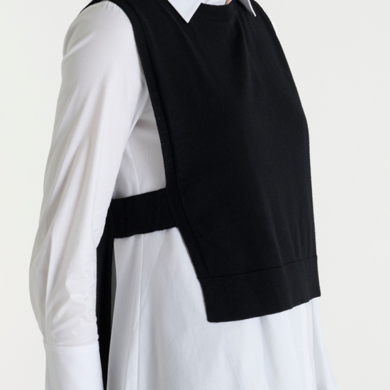 Black pullover vest with ribbed neck knit. Side view.