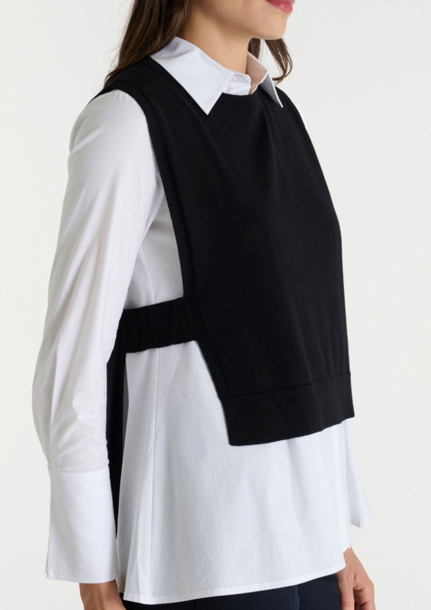 Black pullover vest with ribbed neck knit. Side view.