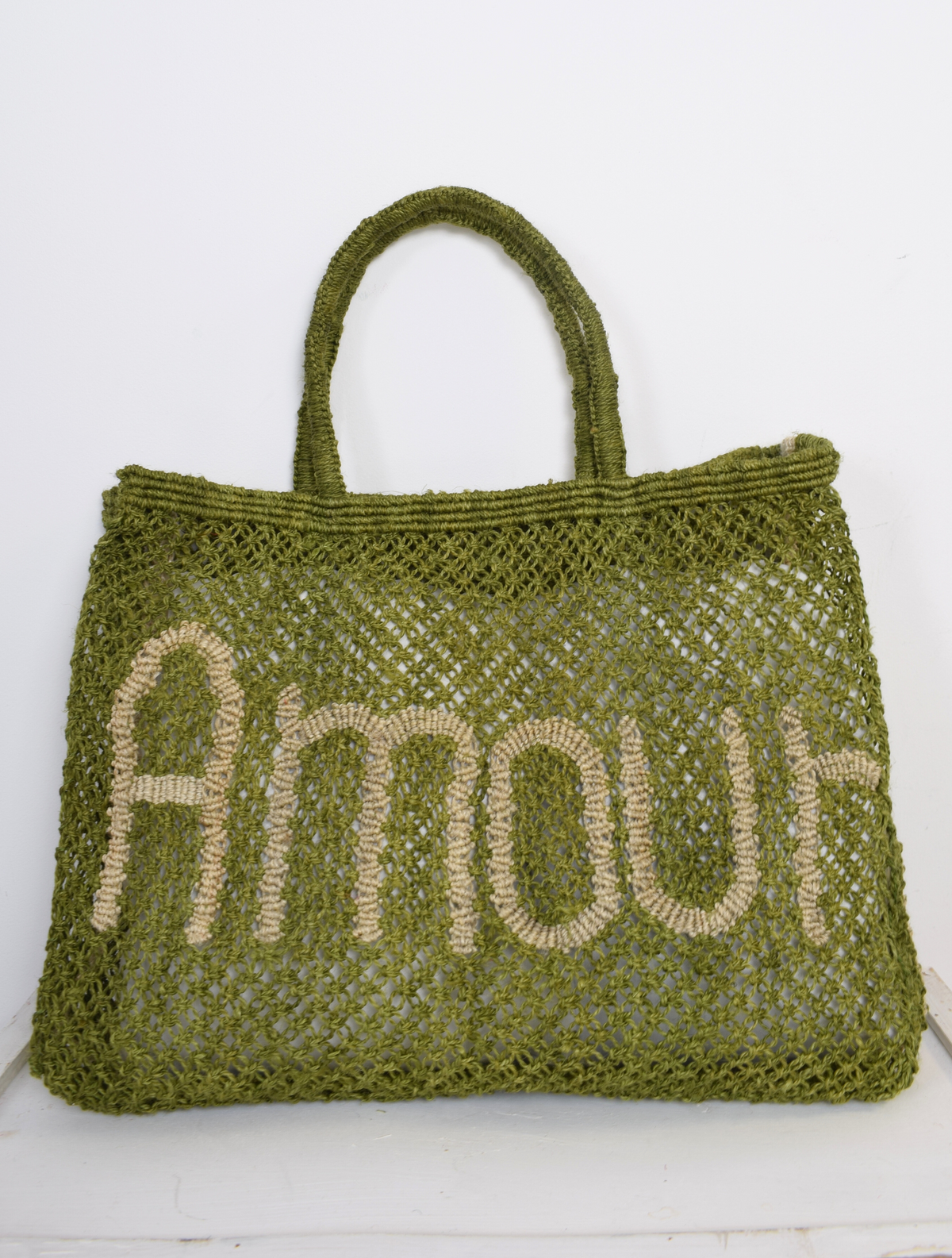 Green woven bag with nude "amour" writing