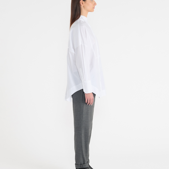 White long classic shirt with wide cuffs and panelling detailing on the front. side view.