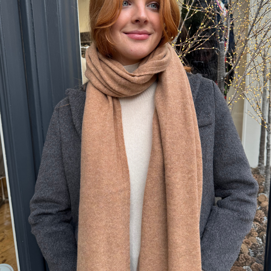 Model wearing grey coat and camel cashmere scarf.