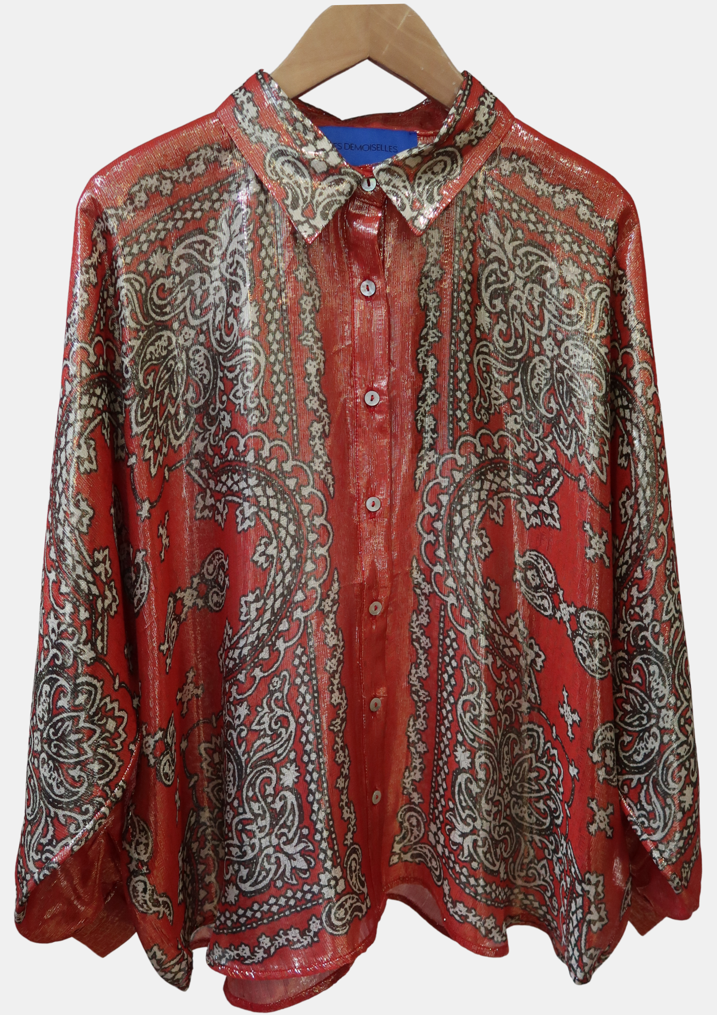 Red and gold patterned shirt on a hanger against a white background.
